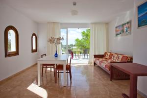 a living room with a table and a couch at Apartamentos Cala Murada Tennis in Cala Murada