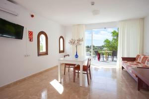 a living room with a table and a couch at Apartamentos Cala Murada Tennis in Cala Murada