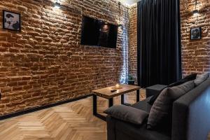 a living room with a couch and a brick wall at Krakowskie30 Loft2 na deptaku in Lublin