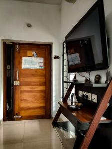 a room with a wooden door and a television on the wall at Mel Ville in Pondicherry