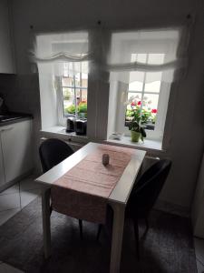eine Küche mit einem Tisch und Stühlen sowie 2 Fenstern in der Unterkunft Ferienwohnung Altstadt in Rottenburg