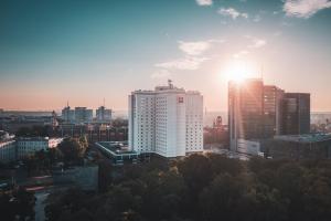 a view of a city skyline with the sun setting at Ibis Poznan Centrum in Poznań