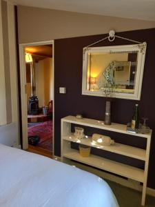 a bedroom with a bed and a mirror on a wall at Adorable Hideaway with log fire and incredible views in Robertsbridge