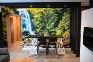 a dining room with a waterfall mural on the wall at Apartament Południowy W80 in Żory