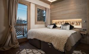 a bedroom with a bed and a window at Rare blend of mountain charm and high performance with all modern amenities in Les Diablerets