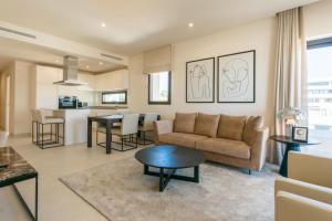 un soggiorno con un divano e un tavolo di Luxury apartment Vida Feliz with sea view 5 min walk to the beach in Jardinana Lotus La Cala de Mijas, Malaga a Mijas Costa