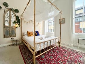 een slaapkamer met een hemelbed en een rood tapijt bij Unique & Luxurious 2 Bedroom City Centre Apartment in Nottingham