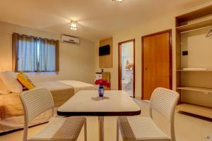 um quarto com uma cama, uma mesa e cadeiras em Pousada Céu & Mar de Taipu em Barra Grande