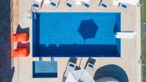 an overhead view of a swimming pool with chairs at Etesians Villa, an essence of timeless beauty, By ThinkVilla in  Episkopi (Chania)