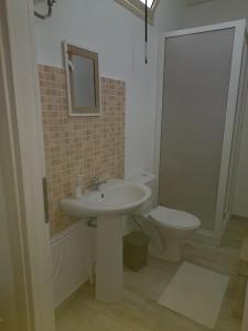 uma casa de banho com um lavatório e um WC em House Garden Adim em Brucoli