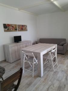 uma mesa branca e cadeiras numa sala de estar em House Garden Adim em Brucoli