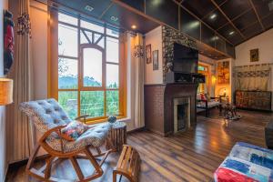 a living room with a fireplace and a chair at StayVista at Spirits Unplugged with Outdoor Pool - Karyali in Nāldera