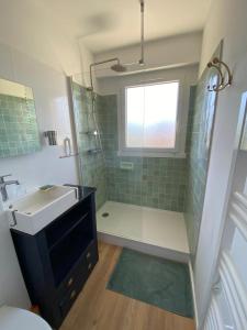 baño con lavabo y ducha con ventana en Les Pins Penchés, en Villers-sur-Mer