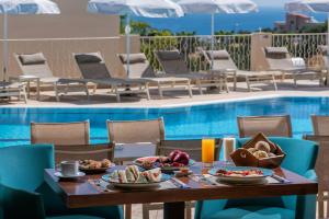 una mesa con comida junto a una piscina en Lofos Apartments, en Hersonissos