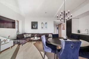 a living room with a table and blue chairs at Amazing luxury apartment on the waterfront! 73sqm in Oslo