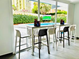 a table and chairs in a room with a window at Trebol One Apartments By Mc in Benidorm +11 photos
