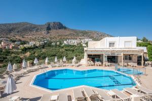 einen Pool mit Stühlen und Sonnenschirmen vor einem Resort in der Unterkunft Lofos Apartments in Hersonissos
