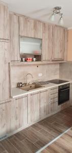 - une cuisine avec des placards en bois et un évier dans l'établissement Apartman Banja Koviljaca, à Banja Koviljača