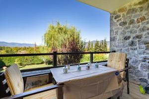 a table and chairs on a balcony with a view at Angel House Greystone Villa Polydrossos in Polydrossos