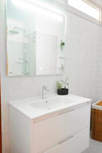 un bagno bianco con lavandino e specchio di Ocean view, Playa San Juan. a Guía de Isora