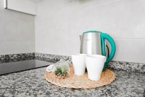 una caffettiera e due tazze bianche su un bancone di Ocean view, Playa San Juan. a Guía de Isora