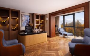 eine Hotellobby mit 2 Stühlen und einer Rezeption in der Unterkunft Swissôtel Wellness Resort Alatau Almaty in Almaty