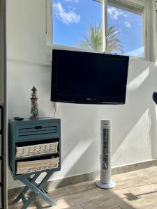 une télévision à écran plat suspendue sur un mur avec un radiateur dans l'établissement CasaBarco, à Costa del Silencio