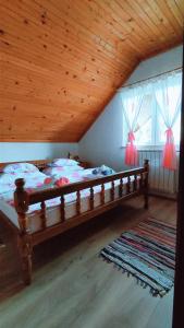 Cama grande en habitación con techo de madera en Kuća za odmor Delak, en Fužine