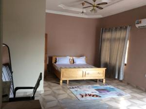 1 dormitorio con 1 cama y ventilador de techo en Patayo Lodge en Kumasi