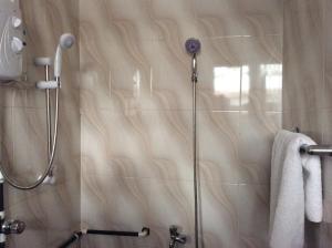 y baño con ducha y puerta de cristal. en Patayo Lodge en Kumasi