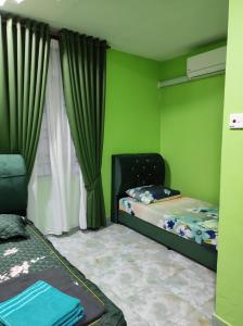 a green room with a bed and a window at CTZ PAROH RIVER PARK in Jertih
