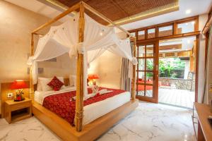 een slaapkamer met een hemelbed bij Nidhi Private Villas in Ubud