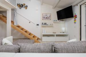 Villetta a Mare في أولبيا: غرفة معيشة مع أريكة ودرج