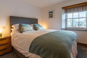 a bedroom with a large bed and a window at 15 The Crescent - Bude Cornwall in Bude