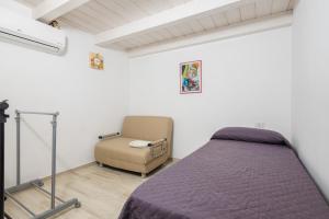 a bedroom with a bed and a chair at Villetta a Mare in Olbia
