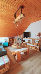 uma sala de estar com um tecto de madeira com um lustre em Kuća za odmor Delak em Fuzine