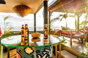 a table with three bottles of beer on a patio at Villa Coco Palm ***** in Saint-Pierre