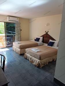 a hotel room with two beds and a balcony at Ban Nam Mao Resort in Na Jomtien