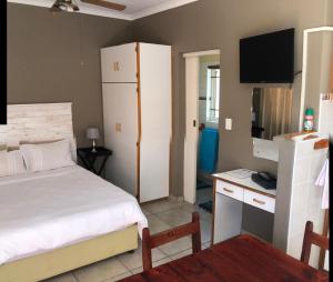 a small bedroom with a bed and a tv at Anas Inn in Walvis Bay