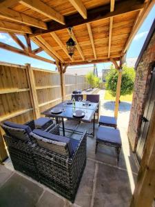 a patio with a table and chairs under a wooden roof at 8 Duke Street - Launceston Cornwall in Launceston