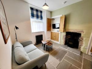 a living room with a couch and a fireplace at 8 Duke Street - Launceston Cornwall in Launceston