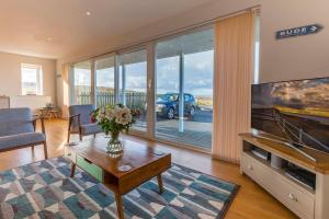 Una sala de estar con un televisor, un sofá y una mesa. en POLDARE - Widemouth Bay Bude Cornwall, en Bude