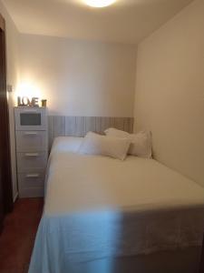 a bedroom with a white bed and a dresser at Apartament - Monte Oiz - 2/4 pax + parking in Sierra Nevada