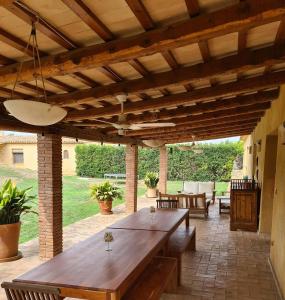 uma área de refeições exterior com uma mesa de madeira e cadeiras em Cal Colina - Karaktervol landhuis met privé zwembad em Pacs del Penedes