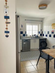 a kitchen with a table and a sink and a stove at Casa da Boa Gente in Cabanas de Tavira