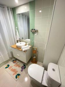 een badkamer met een toilet, een wastafel en een spiegel bij Casa da Boa Gente in Cabanas de Tavira