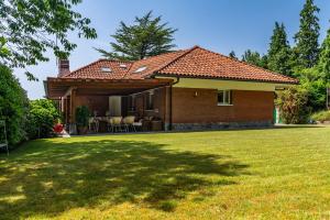 a brick house with a lawn in front of it at Villa Urbasa in San Sebastián