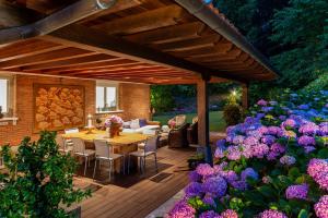 a wooden deck with a table and some purple flowers at Villa Urbasa in San Sebastián