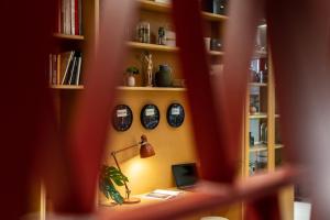 a room with a desk with a lamp and bookshelves at Hotel Altus Poznań Old Town - Destigo Hotels in Poznań +41 photos