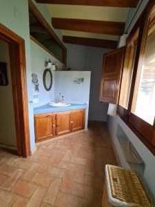 y baño con lavabo y armarios de madera. en Cal Colina - Karaktervol landhuis met privé zwembad, en Pacs del Penedès